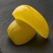 Slices of candied citron on premium black slate, side view, modern culinary setting