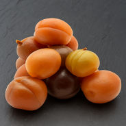 Soft candied apricots with intact pit on high-end slate board