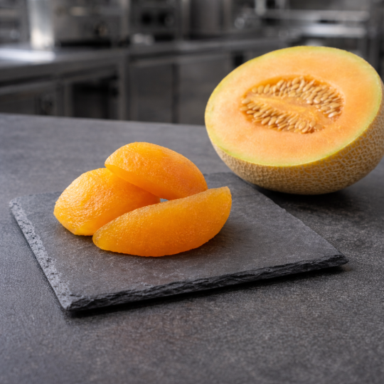 Candied melon pieces presented in a contemporary professional kitchen setting