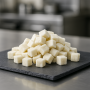 Dehydrated coconut cubes on premium slate board, soft texture