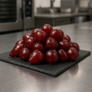 Gekonfijte karmijnperen volledig gepresenteerd op premium leisteen in een professionele keuken