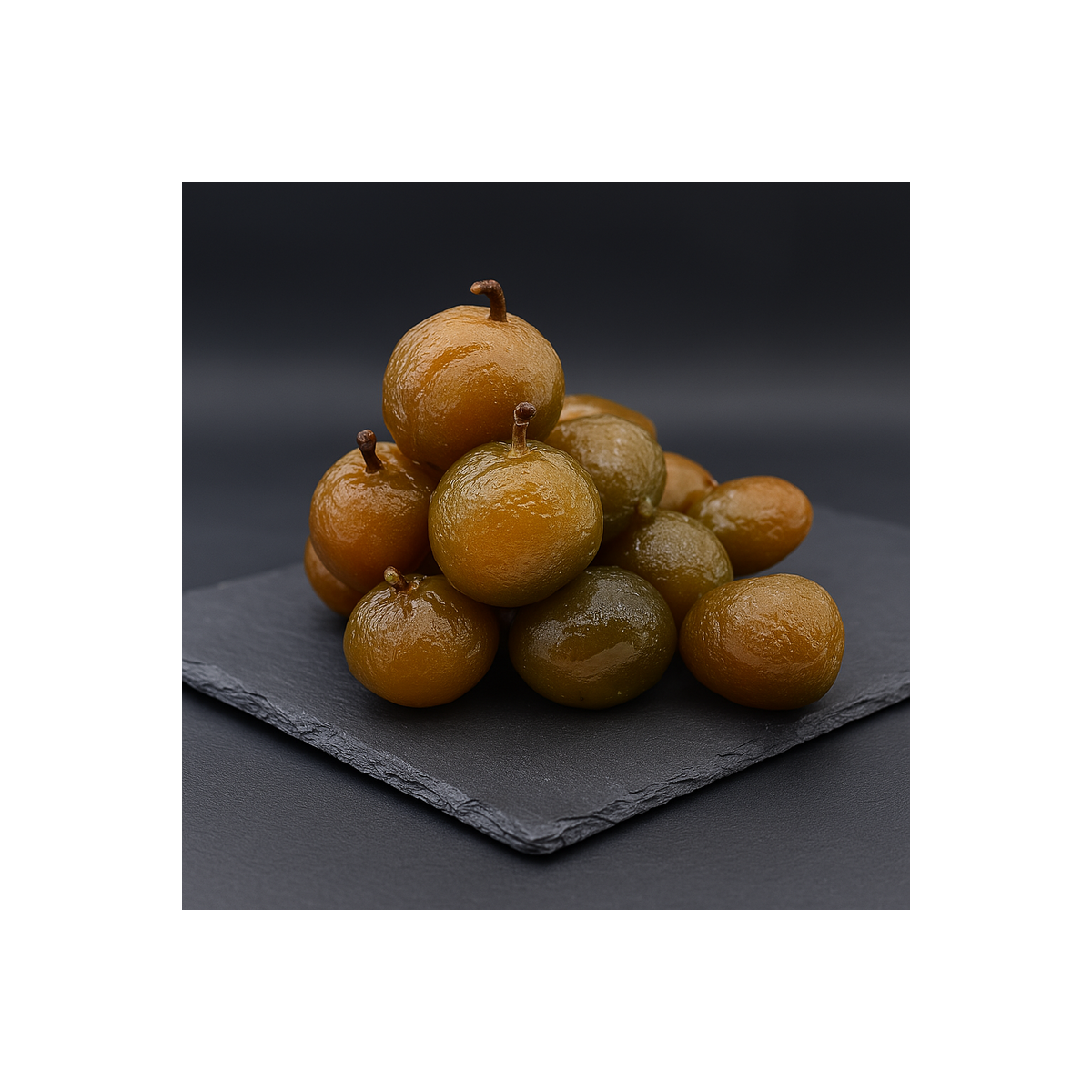 Candied plums displayed on premium slate in a professional kitchen