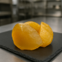 Golden candied melon pieces on slate surface in a professional culinary setting Golden candied melon pieces on slate surface in a professional culinary setting