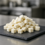 Natural coconut cubes displayed on slate board in a modern culinary setting