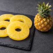 Ananas confit présenté sur plaque en ardoise haut de gamme, vue de dessus, cuisine professionnelle contemporaine